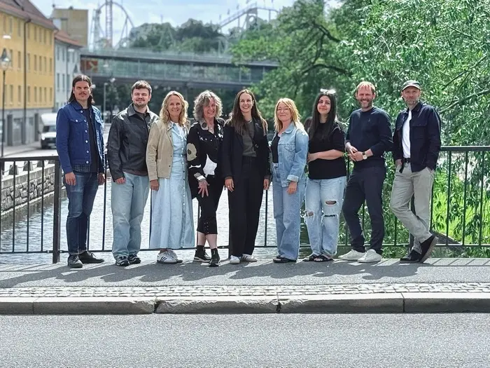 The team behind Tune In West by a railing in Gothenburg